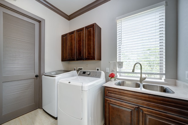 laundry room with crown molding, separate washer and dryer, sink, and cabinets