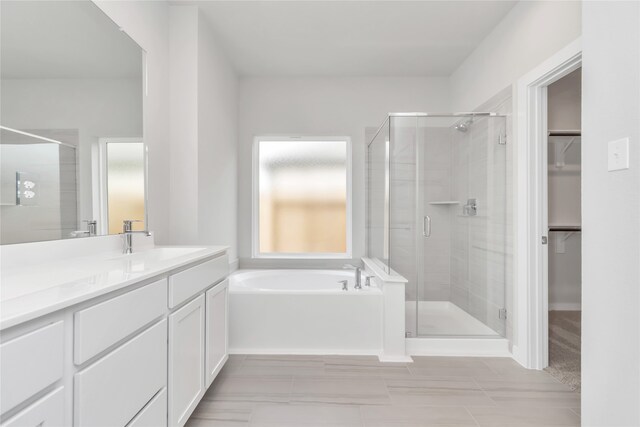 bathroom featuring shower with separate bathtub and vanity