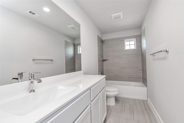 full bathroom featuring vanity, toilet, and tiled shower / bath