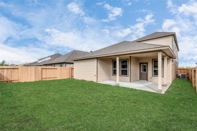 rear view of property featuring a lawn, a patio area, and central air condition unit