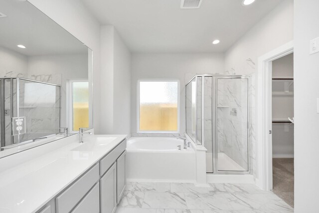 full bathroom featuring a marble finish shower, visible vents, a spacious closet, and a bath