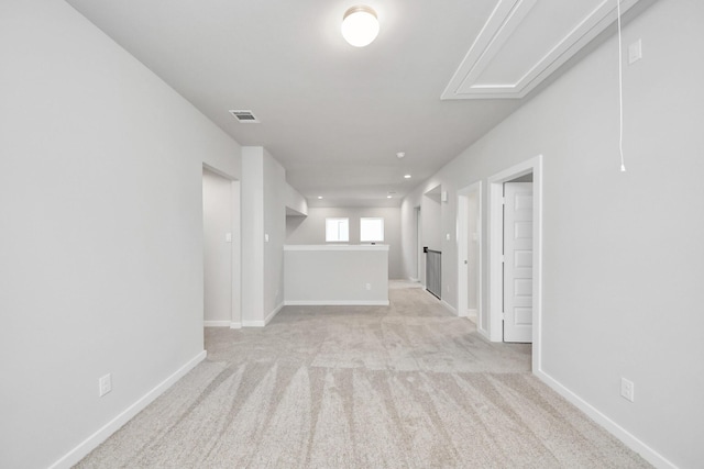 empty room featuring baseboards, visible vents, light carpet, and attic access