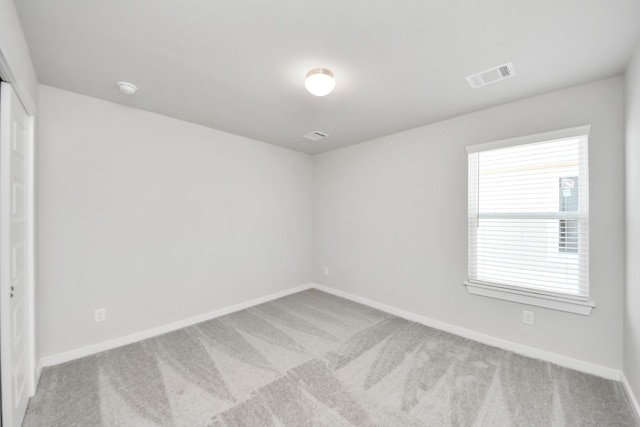 carpeted empty room with baseboards and visible vents