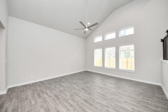 unfurnished living room featuring ceiling fan, baseboards, high vaulted ceiling, and wood finished floors