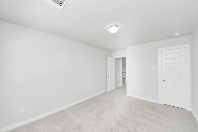 empty room featuring carpet, visible vents, and baseboards