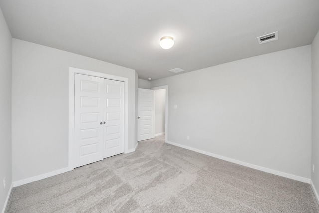 unfurnished bedroom featuring baseboards, visible vents, carpet floors, and a closet