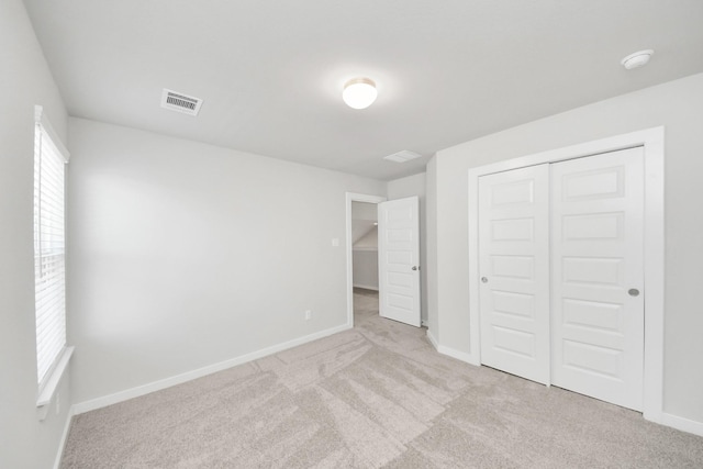 unfurnished bedroom with a closet, baseboards, visible vents, and carpet floors