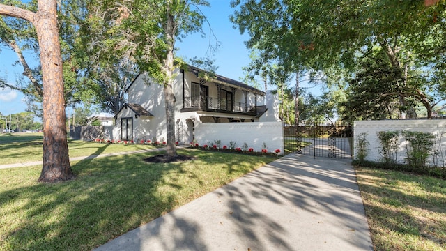 view of front of home with a balcony and a front yard