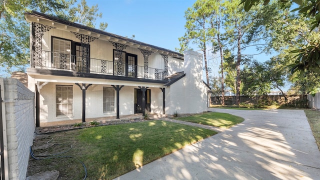 exterior space featuring a balcony and a lawn