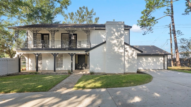 view of front facade with a balcony, a front lawn, and covered porch