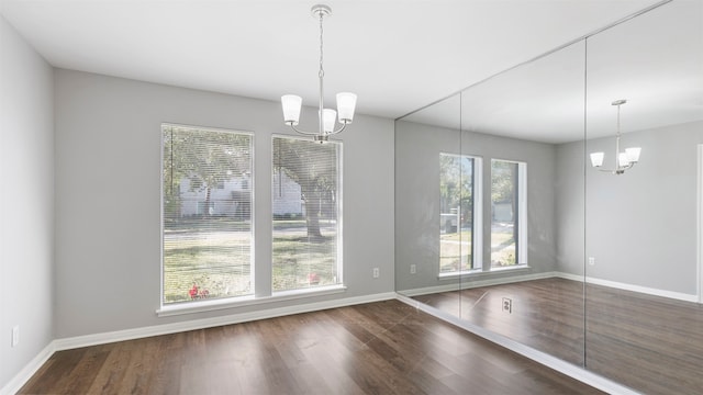 unfurnished dining area featuring an inviting chandelier and dark hardwood / wood-style flooring