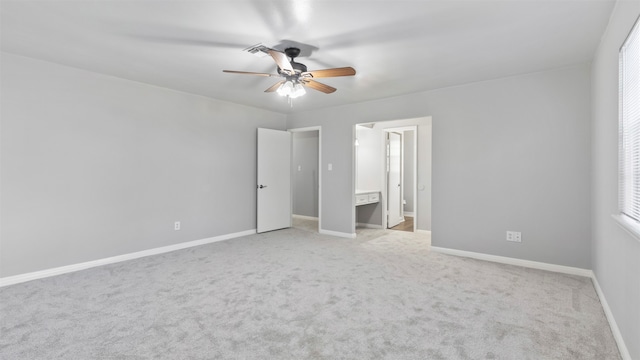 unfurnished bedroom featuring ceiling fan, ensuite bath, and light carpet