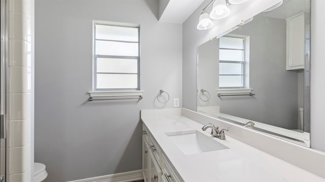 bathroom with plenty of natural light, vanity, and toilet