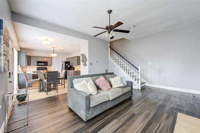 living room with ceiling fan and dark hardwood / wood-style flooring