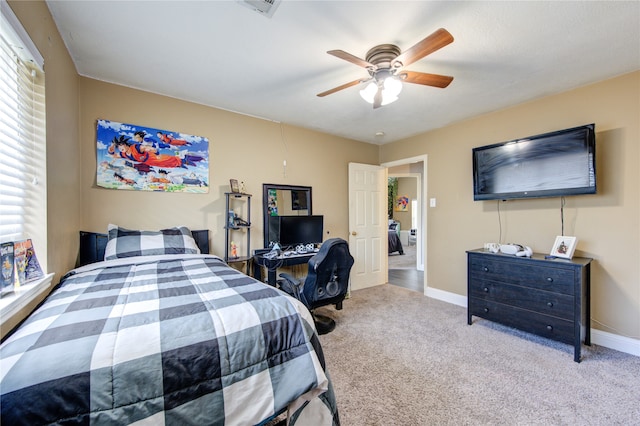 bedroom featuring ceiling fan, multiple windows, and light colored carpet