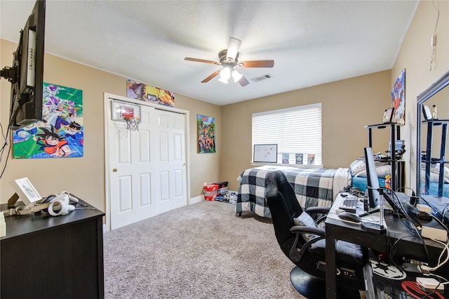 carpeted office space featuring a textured ceiling and ceiling fan