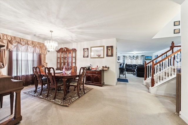 dining area featuring a notable chandelier, a textured ceiling, and light colored carpet