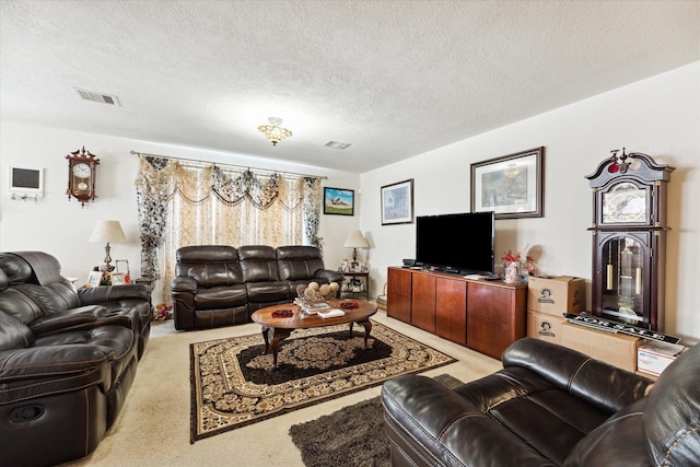living room with visible vents, carpet floors, and a textured ceiling