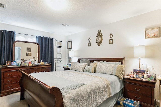 bedroom featuring visible vents, carpet floors, and a textured ceiling