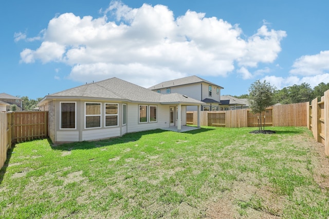 back of property featuring a yard and a patio