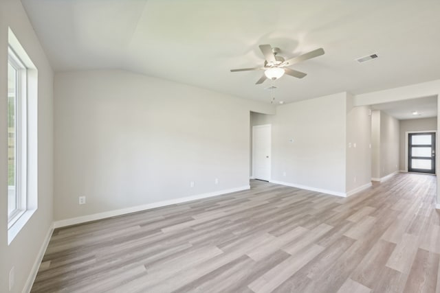 empty room featuring light hardwood / wood-style floors, vaulted ceiling, and ceiling fan