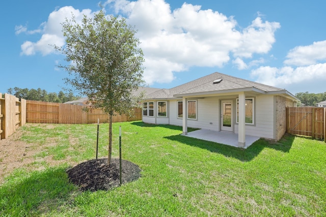 back of property with a lawn and a patio