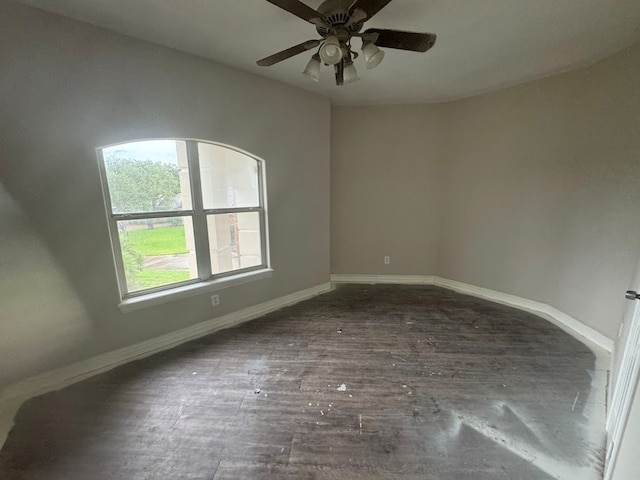 empty room featuring dark wood-type flooring and ceiling fan