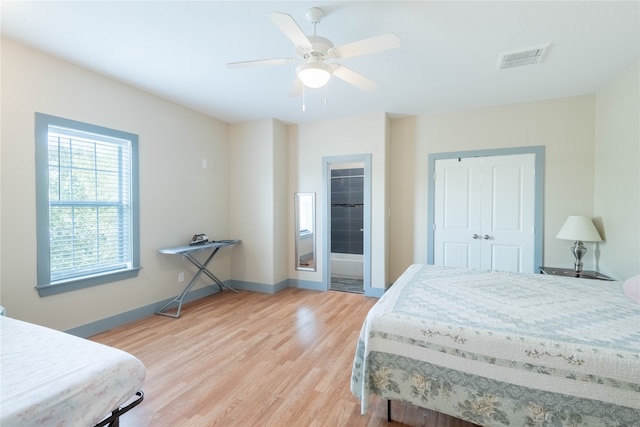 bedroom featuring light hardwood / wood-style floors, ceiling fan, and a closet