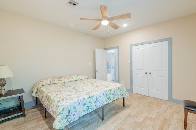 bedroom featuring light hardwood / wood-style flooring, a closet, and ceiling fan