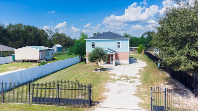 front of property featuring a storage unit and a front lawn