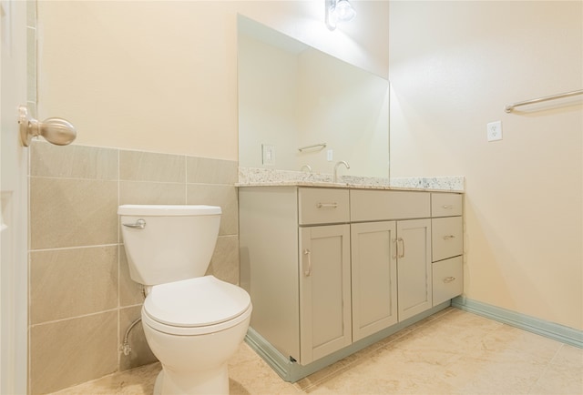 bathroom with vanity, tile walls, toilet, and tile patterned floors