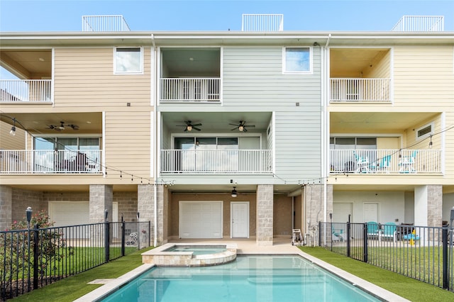 rear view of house with ceiling fan and a balcony