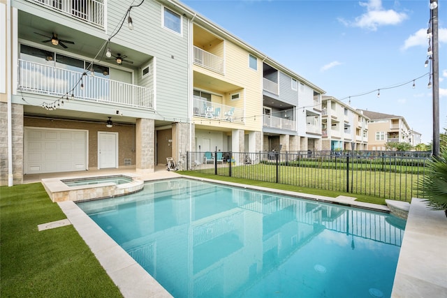 view of swimming pool featuring a yard, an in ground hot tub, and ceiling fan