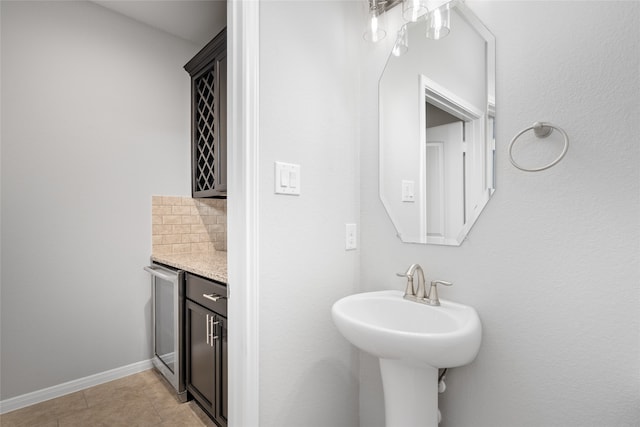 bathroom with wine cooler, tile patterned flooring, and backsplash