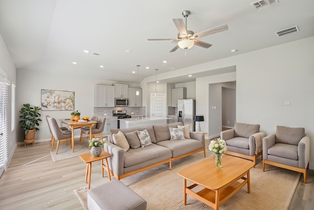 living room with ceiling fan and light hardwood / wood-style flooring