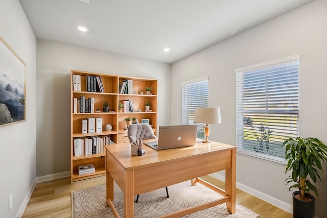 home office with light hardwood / wood-style floors