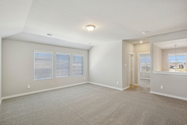 carpeted spare room featuring a textured ceiling