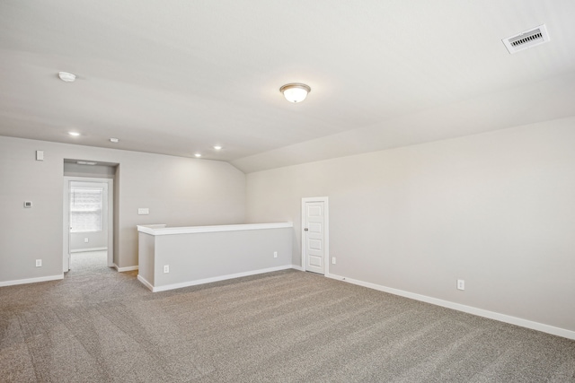 empty room featuring vaulted ceiling and light carpet