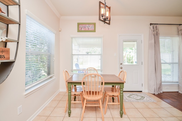 dining space featuring light wood-type flooring, a chandelier, and crown molding