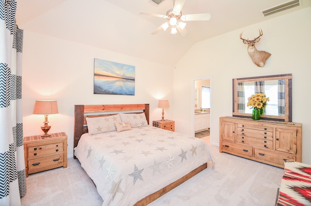 bedroom with connected bathroom, vaulted ceiling, light carpet, and ceiling fan