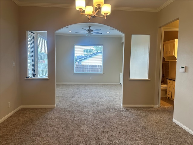 spare room featuring ceiling fan with notable chandelier, carpet, and crown molding