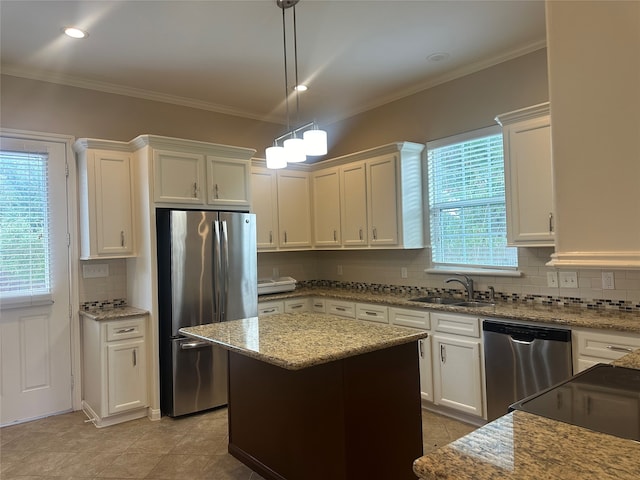 kitchen featuring light stone counters, a center island, sink, white cabinets, and stainless steel appliances