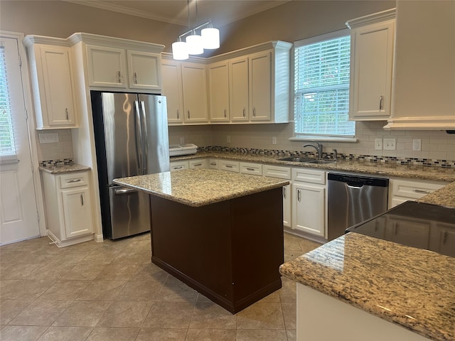 kitchen featuring stainless steel appliances, a center island, tasteful backsplash, and sink