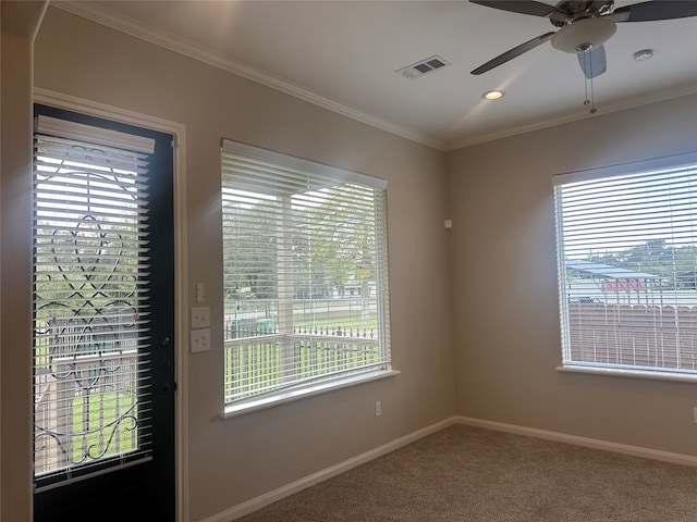 empty room featuring carpet, ceiling fan, plenty of natural light, and crown molding