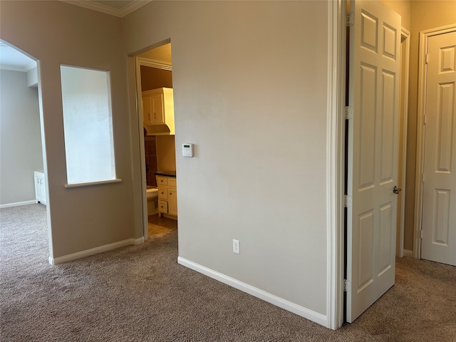 unfurnished bedroom featuring carpet, crown molding, and ensuite bathroom