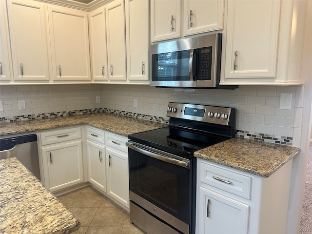 kitchen featuring appliances with stainless steel finishes, decorative backsplash, light tile patterned flooring, light stone counters, and white cabinets