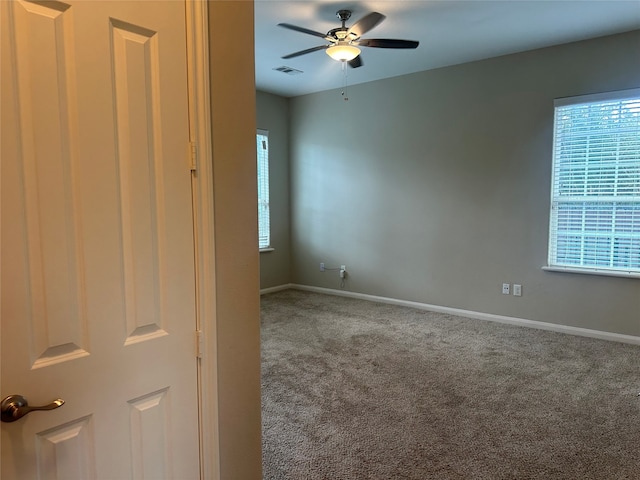 spare room featuring carpet, ceiling fan, and plenty of natural light