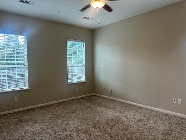 carpeted spare room with ceiling fan