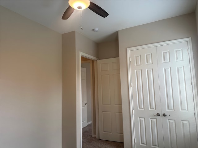 unfurnished bedroom featuring ceiling fan, a closet, and carpet