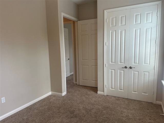 unfurnished bedroom featuring carpet floors and a closet